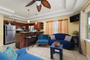 een woonkamer met een blauwe bank en een keuken bij Spacious 10 Bed, Steps to Beach, Private Pool, Yard, Grill in South Padre Island