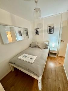 a small bedroom with a bed and a mirror at Cosy Central London Apartment in London
