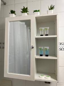 een witte kast met een spiegel in de badkamer bij Cosy Central London Apartment in Londen