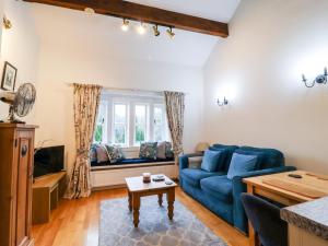 a living room with a blue couch and a table at Yate Cottage in Oxenhope