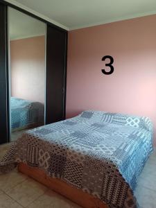 um quarto com uma cama com um número três na parede em Duplex Houssay. em Aldea Camarero