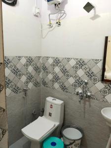 Baño pequeño con aseo y lavamanos en JMD 13 Hotel en Gurgaon