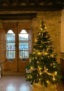 Un árbol de Navidad en una habitación con puerta en El Jardín del Laurel en Candelario