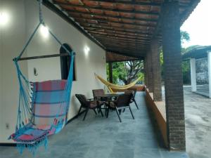 a patio with a hammock and a table and chairs at Casa de Praia em Itaparica in Itaparica