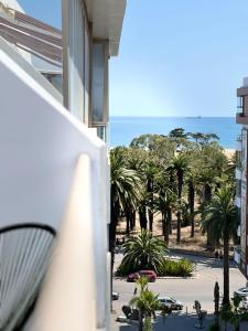 einen Balkon mit Blick auf den Strand und die Palmen in der Unterkunft Appartement CosyRelax au Cœur du Parc - Vue sur mer - Mohammedia in Mohammedia