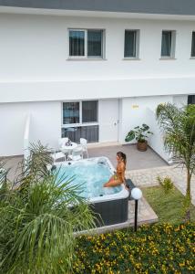 a woman sitting in a hot tub in a courtyard at Vascellero Club Resort in Cariati