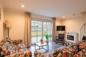 a living room with a couch and a tv and a fireplace at Villa Zuiderduin cottage in Zoutelande