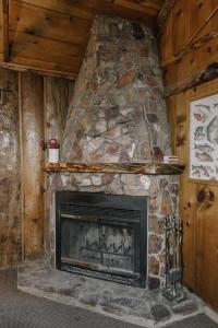 kamienny kominek w pokoju z kamienną ścianą w obiekcie 2411 - Oak Knoll Duplex Studio #14 cabin w mieście Big Bear Lake