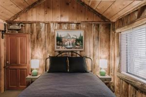 1 dormitorio con 1 cama en una habitación con paredes de madera en 2411 - Oak Knoll Duplex Studio #14 cabin en Big Bear Lake