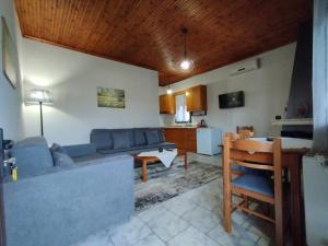 a living room with a blue couch and a kitchen at Guesthouse Mythos in Orma