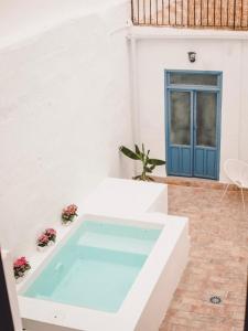 a hot tub in a courtyard with a blue door at Casa del Azucar in Motril