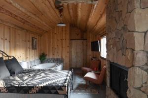 a bedroom with a bed and a stone wall at 2412 - Oak Knoll Studio with Jacuzzi #15 cabin in Big Bear Lake