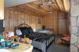 1 dormitorio con 1 cama en una pared de madera en 2412 - Oak Knoll Studio with Jacuzzi #15 cabin en Big Bear Lake
