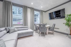 a living room with a couch and a table at Tottenham Court's House - 2 Bed in London