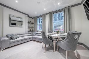 a living room with a couch and a table and chairs at Tottenham Court's House - 2 Bed in London
