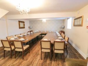 a large dining room with a long table and chairs at Honeysuckle in Filey