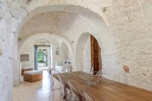 een grote eetkamer met een tafel en stoelen bij Trulli Terrarossa con Piscina in Martina Franca
