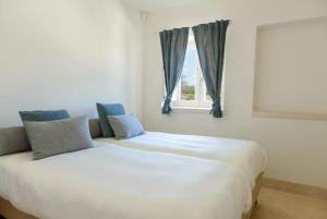 een slaapkamer met een groot wit bed en een raam bij Trulli Terrarossa con Piscina in Martina Franca +37 foto's