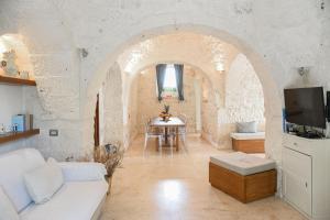 een woonkamer met een bank en een tafel bij Trulli Terrarossa con Piscina in Martina Franca