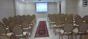 una sala de conferencias con sillas y una pantalla de proyección en HOTEL PALACE AL SALAM , Beni Mellal, en Beni Mellal