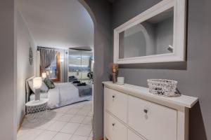1 dormitorio con 1 cama y vestidor con espejo en Charme Studio - Parcheggio a 20 Mt, en Vicenza