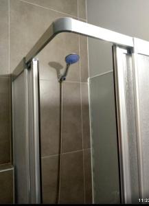 a shower with a blue shower head in a bathroom at Soli centr apartman in Mezitli