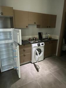eine Küche mit einer Waschmaschine und einem Waschbecken in der Unterkunft Soli centr apartman in Mezitli