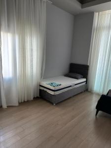 ein Schlafzimmer mit einem Bett in einem Zimmer mit Vorhängen in der Unterkunft Soli centr apartman in Mezitli