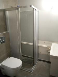 a bathroom with a shower with a toilet and a sink at Soli centr apartman in Mezitli