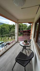 patio con mesa y sillas en el balcón en Casa M&M, en Vişeu de Sus