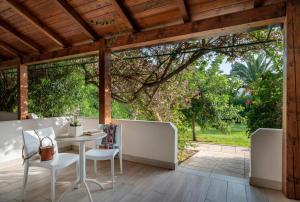 a patio with a table and chairs and a large window at Vascellero Club Resort in Cariati