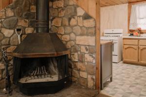 a stone fireplace in a kitchen with a stove at 2406 - Oak Knoll #8 cabin in Big Bear Lake