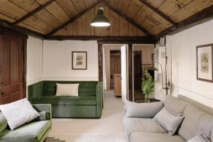 ein Wohnzimmer mit einem grünen Sofa und Stühlen in der Unterkunft 2409 - Oak Knoll #11 cabin in Big Bear Lake