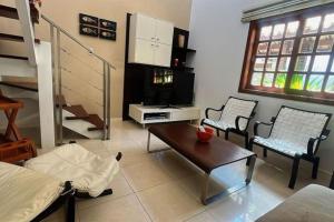 uma sala de estar com duas cadeiras e uma mesa em Apartamento duplex em Praia do Forte - 2 suítes na Praia do Forte