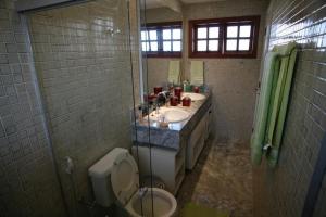 łazienka z 2 umywalkami, toaletą i prysznicem w obiekcie Apartamento duplex em Praia do Forte - 2 suítes w mieście Praia do Forte