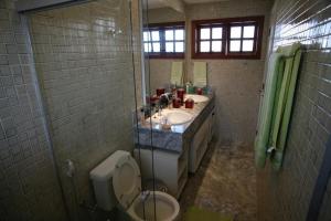 un bagno con due lavandini, un water e una doccia di Apartamento duplex em Praia do Forte - 2 suítes a Praia do Forte Altre 3 foto