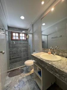 a bathroom with a toilet and a sink and a shower at Apartamento duplex em Praia do Forte - 2 suítes in Praia do Forte