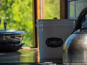 un cubo de basura sentado en una mesa junto a una olla en La Huala en San Carlos de Bariloche