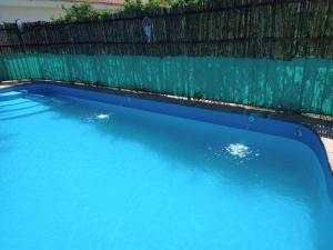 una piscina blu accanto a una recinzione di CABAÑAS DE MORA a Villa Santa Cruz del Lago