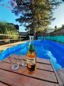 una botella de cerveza sentada en una mesa cerca de una piscina en CABAÑAS DE MORA en Villa Santa Cruz del Lago