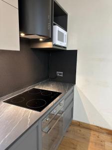 a kitchen with a stove and a microwave at MB26 in Courmayeur