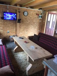 ein Wohnzimmer mit einem Holztisch und einem Sofa in der Unterkunft Vikendica Na Plivi in Šipovo