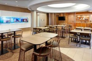 a restaurant with tables and chairs and a flat screen tv at SpringHill Suites Houston NASA/Webster in Webster