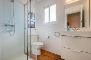 a bathroom with a toilet and a glass shower at apartamento edificio migjorn santo tomas in Santo Tomás