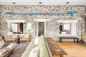 a living room with a couch and a brick wall at River Lodge by AvantStay 11 BR Historic Estate w Pool Views of Hudson in Hudson