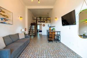 Lofts At San Agustin في سان خوان: غرفة معيشة مع أريكة وتلفزيون بشاشة مسطحة