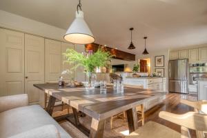 uma cozinha com uma mesa de madeira e uma sala de jantar em Cortland by AvantStay Charming Heritage Estate w Private Lake Pool em Saugerties