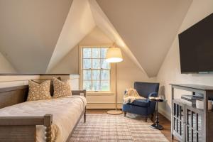um quarto com uma cama, uma cadeira e uma janela em Cortland by AvantStay Charming Heritage Estate w Private Lake Pool em Saugerties