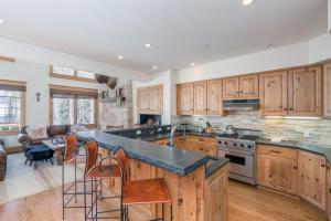 a kitchen with wooden cabinets and a stove top oven at Telemark B by AvantStay Ski In Ski Out at the Heart of Mountain Village in Telluride