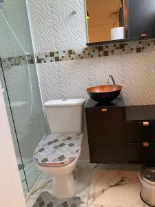 uma casa de banho com um WC e um lavatório em pousada fast sleep no Guarujá